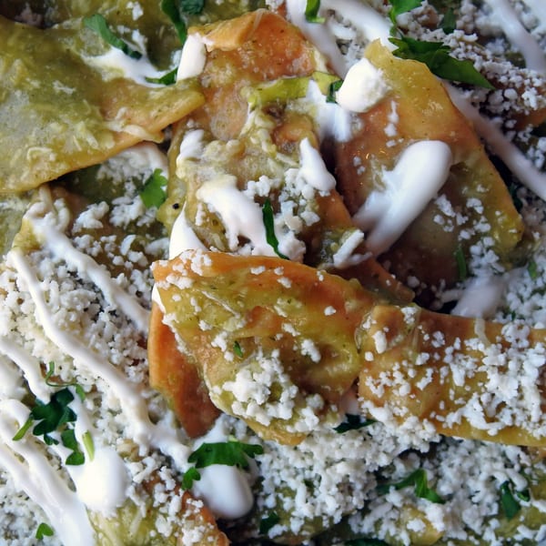 Close-up of Cafe La Taza's chilaquiles with green sauce, crumbled cheese, and crema.